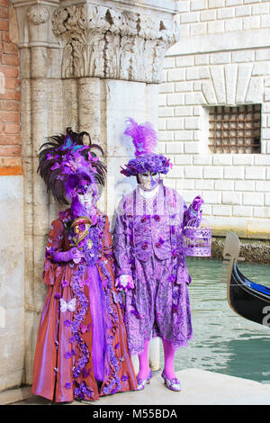 A pair of costumed people outside the doge's Palace during the Carnival of Venice (Carnivale di Venezia) in Venice, Italy Stock Photo