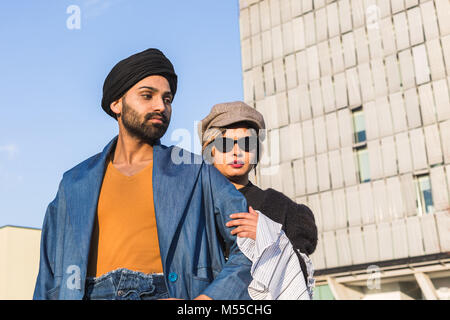 Beautiful Indian couple posing in an urban context. Street fashion and style. Stock Photo