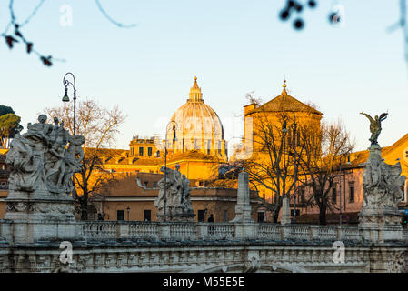 The sunrise hits St Peter's Cathedral and the Vatican but has yet to reach ponte vittorio emanuele II bridge in the foreground. Rome. Italy. Stock Photo