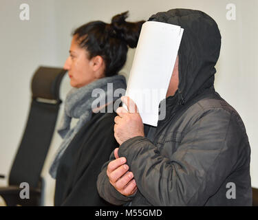The defendant holds paper in front of his face and stands in the courtroom with handcuffs during the trafficking trial at the district court in Frankfurt an der Oder, Germany 20 February 2018. The defendant drove the trafficking truck with 71 refugees. The Public's Prosecutors Office accuses the defendant of smuggling 20 people from the Iraq and Iran in August 2017 and 51 people from Syria and the Iraq in September from Romania to Germany. Photo: Patrick Pleul/dpa-Zentralbild/ZB Stock Photo