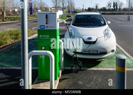 Maynooth, County Kildare, Ireland. 20 Feb 2018: Electric vehicle Ecar Nissan Note being charged at the ESB charging point. Charging car battery becoming more and more accessible with increasing number of charge stations now easily found on-street, shopping centres and car parks. Stock Photo