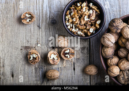 walnuts in a clay plate on a wooden background. close up. top view Stock Photo