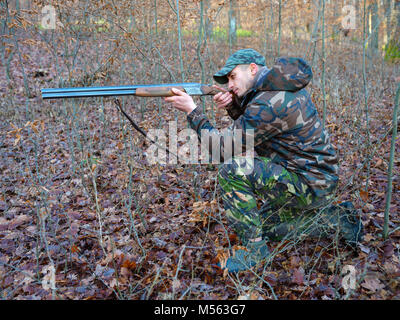 Hunter in camo suit with double barrel shotgun Stock Photo