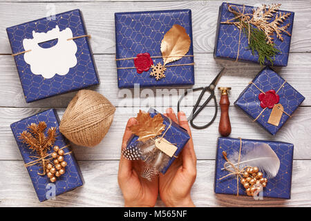 Woman wrapping christmas presents over wooden background Stock Photo