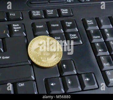 golden bitcoin on black keyboard closeup Stock Photo