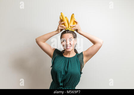 Beautiful model makes a crown out of banana fruits Stock Photo