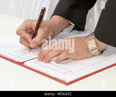 Business worker signing the contract to conclude a deal Stock Photo