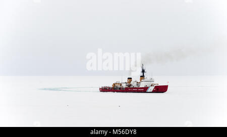 McMurdo Station, Antarctica - 13th Jan, 2015: US Coast Guard Cutter Polar Star breaks a channel in the sea ice to provide access for a supply vessel.