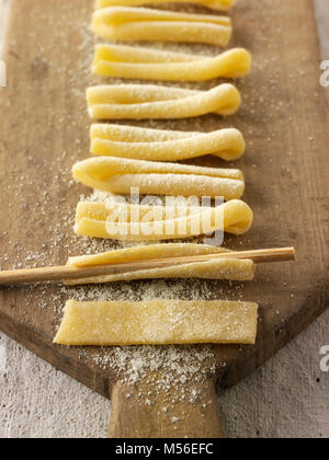 Traditional Italaian Casarecce pasta being made and shaped in a rustic setting Stock Photo