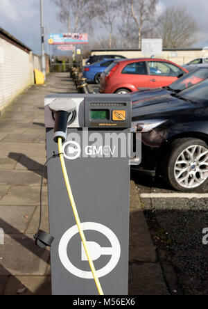 Gmev electric vehicle charge point, electric car charging point, lead and plug connected, cars in background in off street car park bury lancashire uk Stock Photo
