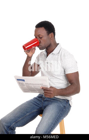 African man drinking coffee, reading the paper Stock Photo