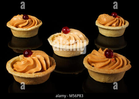 Small cakes with cream on a black background Stock Photo