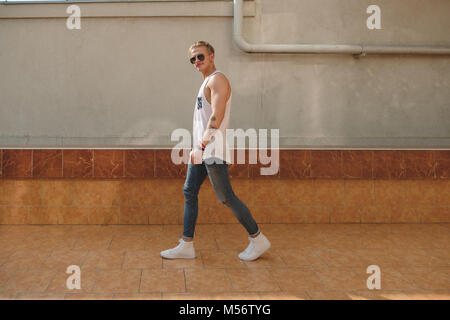 Young tattooed hipster man with sunglasses walking  Stock Photo