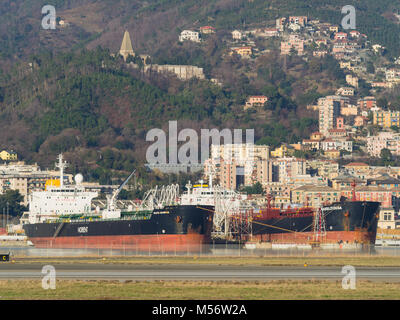 Genoa Italy December 23, 2017: big oil chemical tankers moored in a port next to the buildings of the city Stock Photo