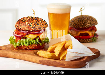 Two burgers with french fries and glass of beer Stock Photo