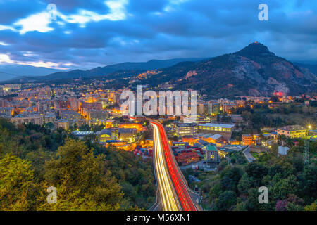 View on highway in the west part of Genoa by night, Italy, a view of industrial and residential area. Stock Photo