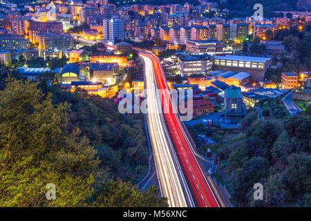 View on highway in the west part of Genoa by night, Italy, a view of industrial and residential area. Stock Photo