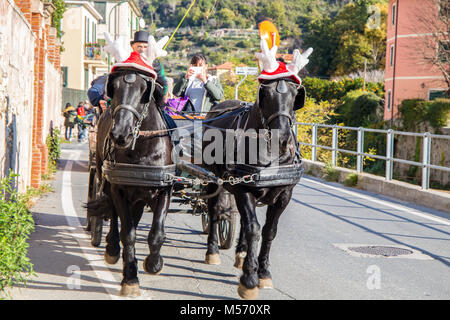 FINALE LIGURE, ITALY DECEMBER 9, 2016 - Black horses with carriage with funny Christmas hats Stock Photo