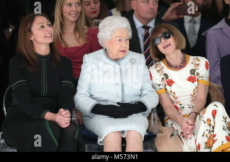 Queen Elizabeth II sits next to Anna Wintour (right) and Caroline Rush, chief executive of the British Fashion Council (BFC) (left) as they view Richard Quinn's runway show before presenting him with the inaugural Queen Elizabeth II Award for British Design as she visits London Fashion Week's BFC Show Space in central London. Stock Photo