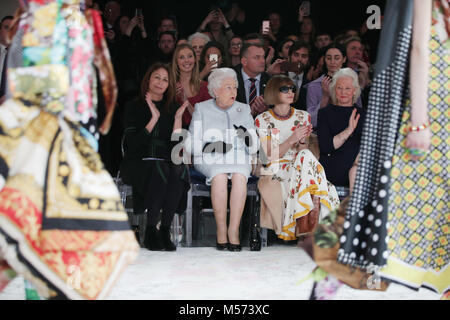 Queen Elizabeth II reacts as she sits with Anna Wintour (second right) and Caroline Rush (left), chief executive of the British Fashion Council (BFC) and royal dressmaker Angela Kelly (right), as they view Richard Quinn's runway show before presenting him with the inaugural Queen Elizabeth II Award for British Design as she visits London Fashion Week's BFC Show Space in central London. Stock Photo