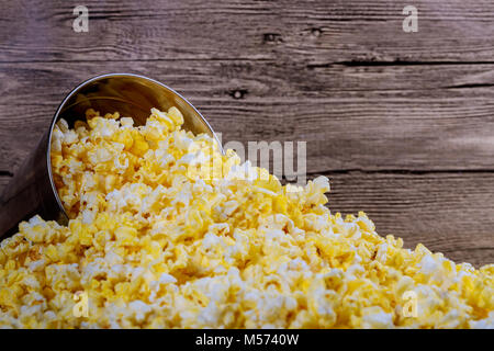 Box of popcorn spilled on wood background. Stock Photo
