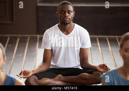 Young sporty black man sitting in Sukhasana exercise Stock Photo