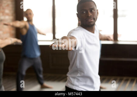 Young sporty black man in Warrior two exercise Stock Photo