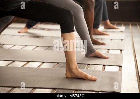 Group of yogi people in Warrior Two legs close up Stock Photo