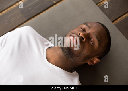 Young black man lying in Dead Body exercise Stock Photo
