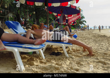funny shot of caucasian middle aged man lying face down on lounger sunbathing on beach, no face Stock Photo