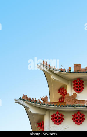 Modern building with chinese-inspired architecture featuring curved roofs, ridges decorated with ceramic figurines, dragon shaped beams, glazed roof t Stock Photo