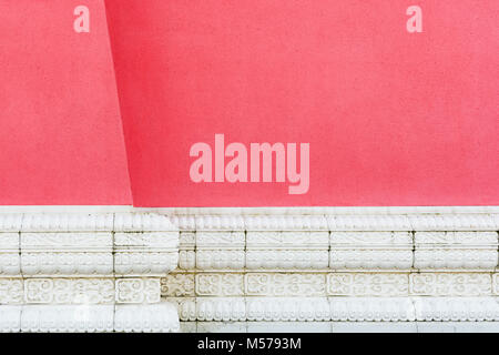 Front view of a red rendered wall with white carved cornice at the base. Stock Photo