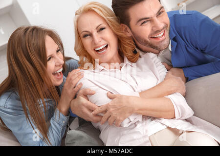 Young family with mother-in-law at home weekend laughing cheerful Stock Photo