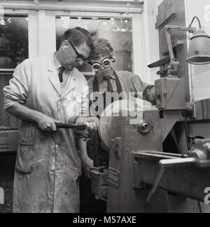 1968, historical, South London, England, young teenager boy at a state boarding school in a workshop with a teacher using a lath during a metalwork class. Stock Photo