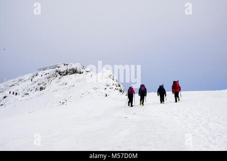 Hikers hiking up to Snowdon mountain summit with snow in winter in Snowdonia National Park (Eryri). North Wales, UK, Britain Stock Photo