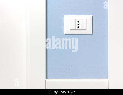 Empty wall socket on a light blue interior wall Stock Photo