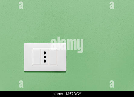 Empty wall socket on a green interior wall Stock Photo