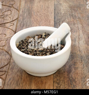 Comfrey root herb used in alternative and chinese herbal medicine, is used as a salve and can treat skin ailments in a mortar with pestle . Stock Photo