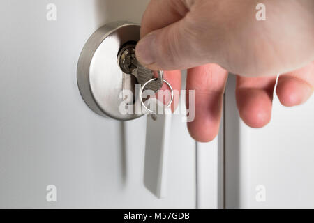 Locking up or unlocking door with key in hand Stock Photo
