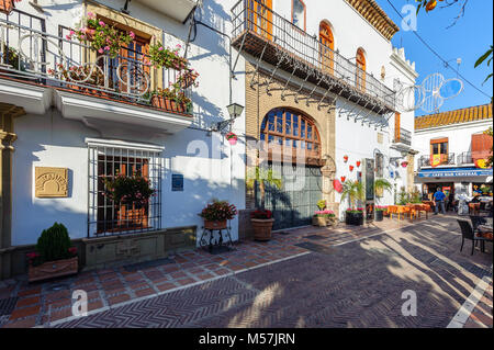 MARBELLA, SPAIN - DECEMBER 2017: Traditional Spanish narrow street with souvenir shop and beautiful architecture in historical part of town Stock Photo