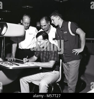 1960s, USA, historical picture, team-members gather round to see a player marking the scorecard at a booth in a ten-pin bowling alley. Television made ten-pin bowling highly popular in the USA at this time and league bowling became a key leisure activity. Stock Photo