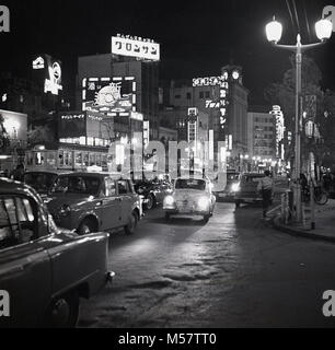 Tokyo, Japan, 1950s, historical picture showing the neon lighting of the city in the evening with the streets busy with motor vehicles. Stock Photo