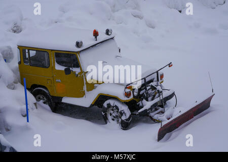 A Toyota Land Cruiser equiped with snow-plow cleans a road covered with fresh snow, Arolla, Val d'Herens, Valais, Swiss Stock Photo