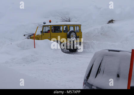 A Toyota Land Cruiser equiped with snow-plow cleans a road covered with fresh snow, Arolla, Val d'Herens, Valais, Swiss Stock Photo