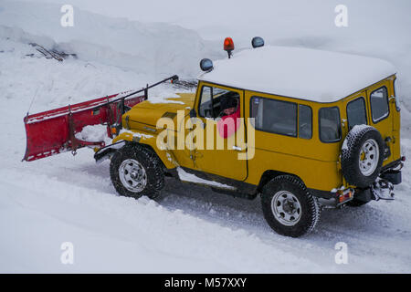 A Toyota Land Cruiser equiped with snow-plow cleans a road covered with fresh snow, Arolla, Val d'Herens, Valais, Swiss Stock Photo