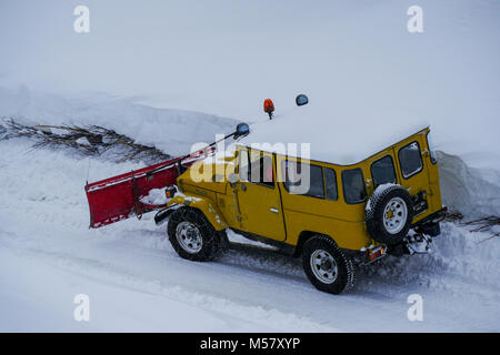 A Toyota Land Cruiser equiped with snow-plow cleans a road covered with fresh snow, Arolla, Val d'Herens, Valais, Swiss Stock Photo