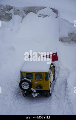 A Toyota Land Cruiser equiped with snow-plow cleans a road covered with fresh snow, Arolla, Val d'Herens, Valais, Swiss Stock Photo