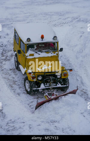 A Toyota Land Cruiser equiped with snow-plow cleans a road covered with fresh snow, Arolla, Val d'Herens, Valais, Swiss Stock Photo