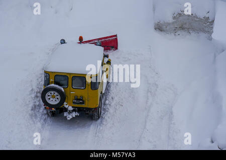 A Toyota Land Cruiser equiped with snow-plow cleans a road covered with fresh snow, Arolla, Val d'Herens, Valais, Swiss Stock Photo