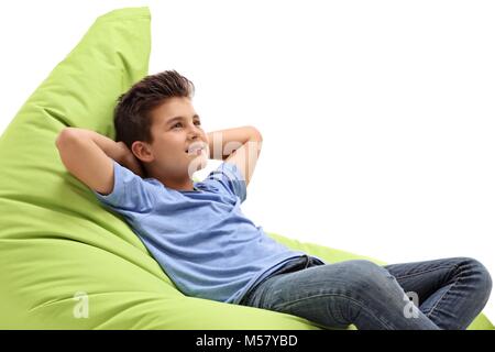 Little boy sitting on a green beanbag isolated on white background Stock Photo